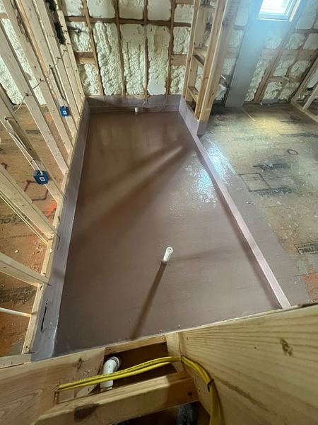 On-site fiberglass laminated shower pan over a framed wood substrate