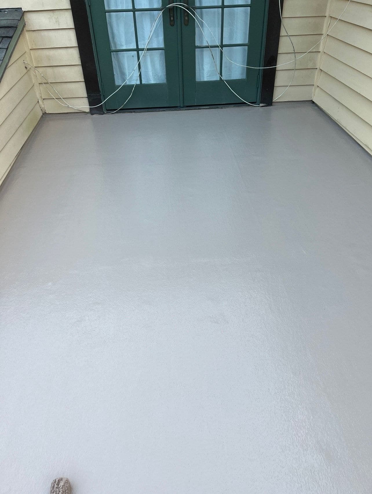 Finished waterproof fiberglass balcony deck with outdoor seating installed by Atinez